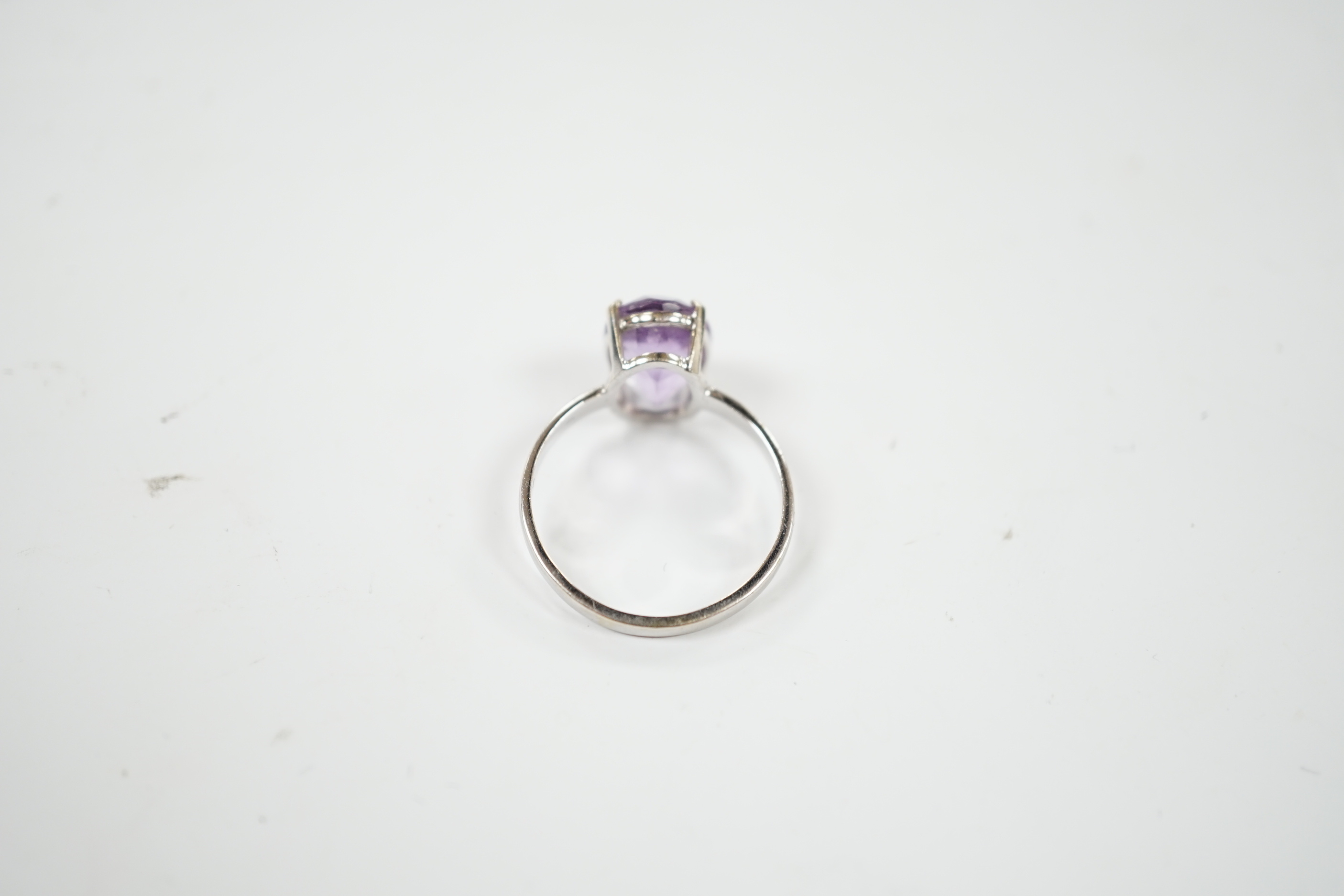 A 750 white metal and oval cut amethyst set ring, size O/P, gross weight 3.1 grams.